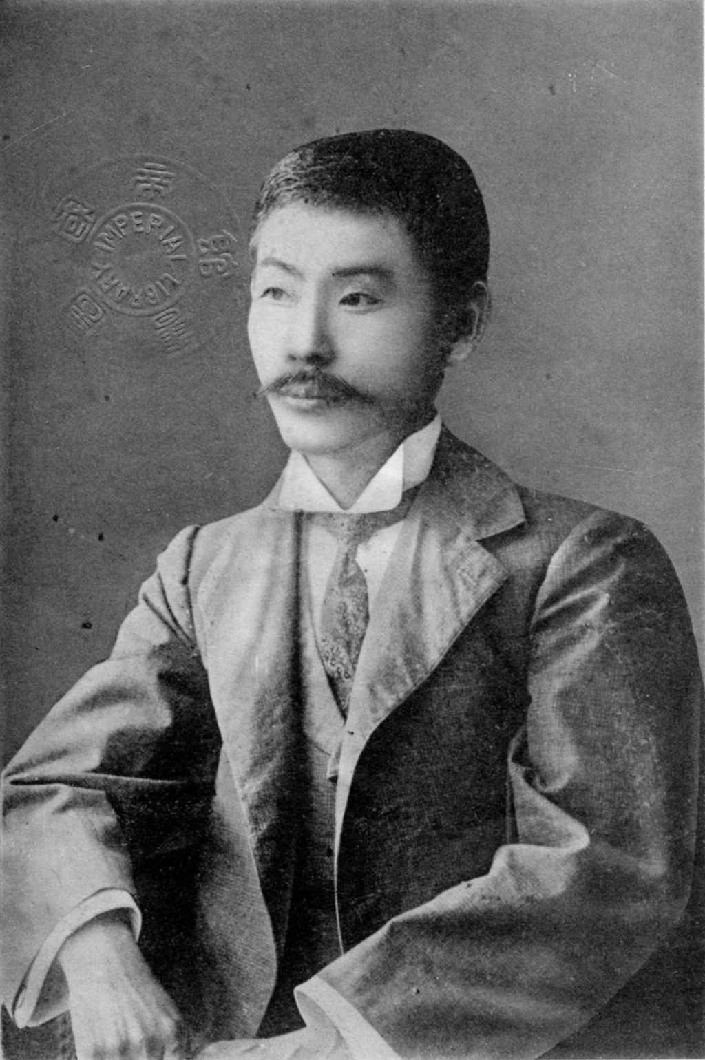 口ひげをたくわえ、背広姿で椅子にもたれる国木田独歩の肖像写真。