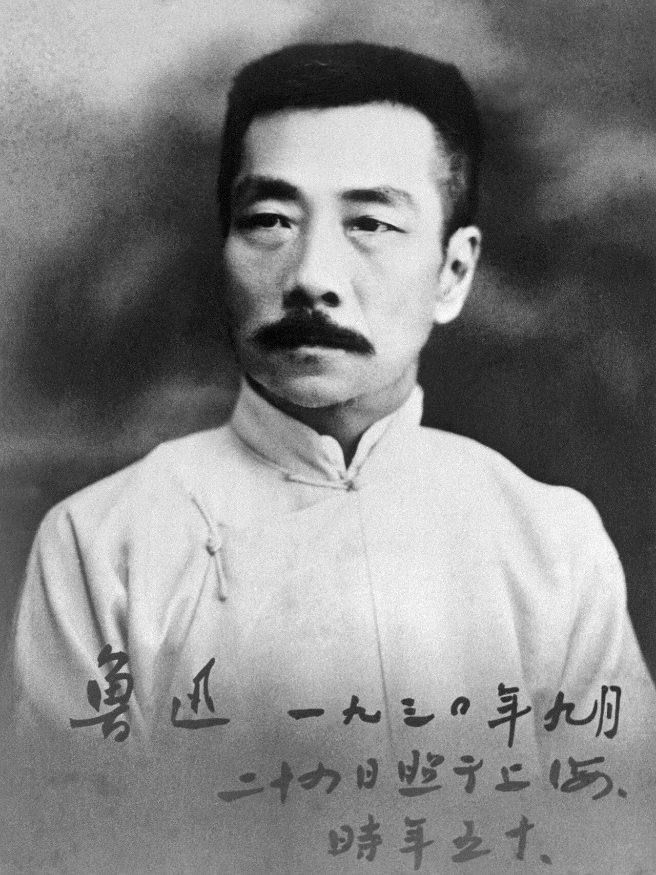 詰襟の上着を着た魯迅の肖像写真。下部に本人の書き入れがある。